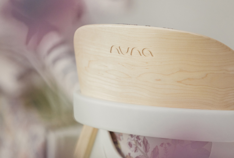 Close up of Nuna logo engraved in wood on back of BRYN high chair