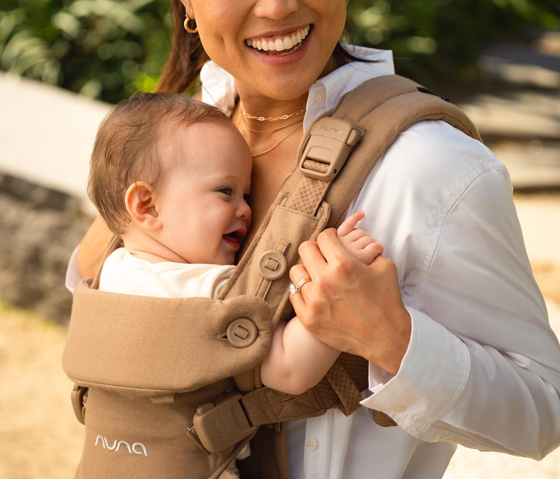 Close up of woman holding baby's hands in a CUDL luxe with detail of Magnetech snap on her shoulder